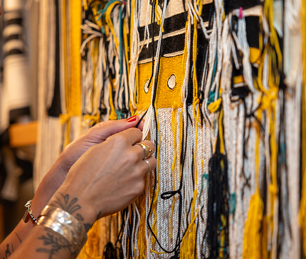 An artist working by hand on a Northwest Coast textile