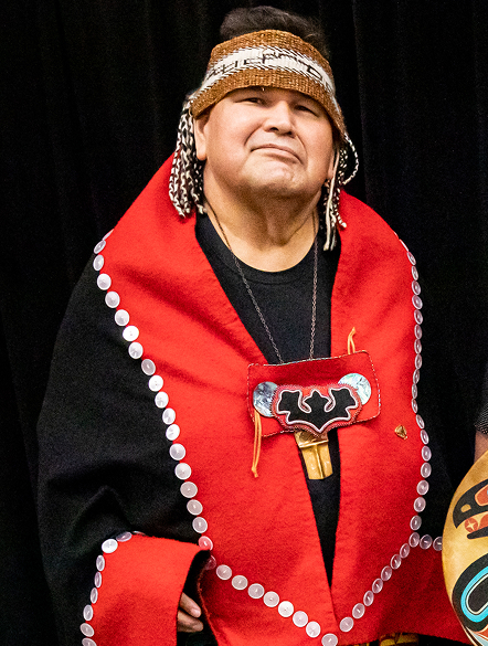 Alfie Price wearing red and black regalia and a woven headband