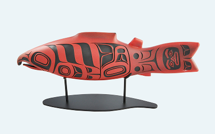 Red and black Northwest Coast salmon sculpture displayed on a stand