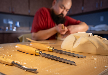 Northwest Coast artist carving wood with hand tools