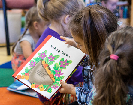 A child reads the Picking Berries picture book