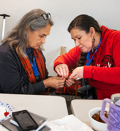 Two Indigenous educators work together on a hands-on cultural activity