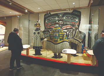 Visitors viewing regalia and cultural objects in the Walter Soboleff Building exhibit gallery