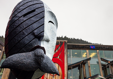 Monumental carved mask outside Atnané Hít