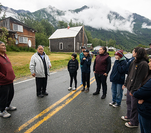Educators gather on a village street beneath misty mountains