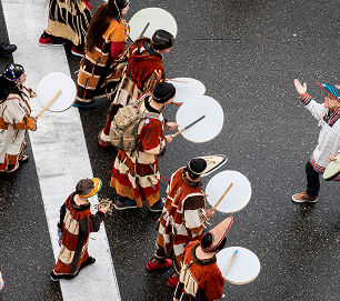 Drummers in traditional regalia walk together in the Celebration parade