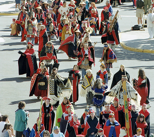 A large procession of Celebration participants wearing traditional regalia