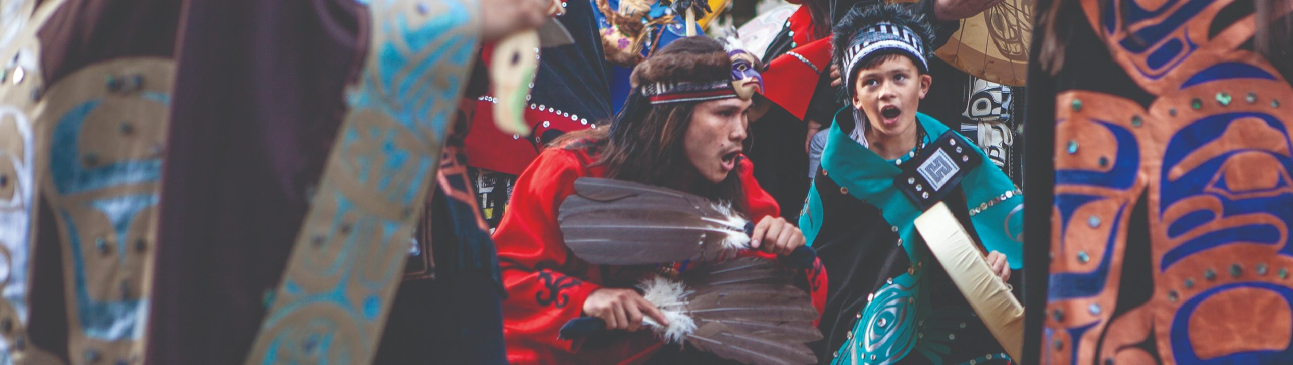 Celebration dancers wearing red and turquoise regalia