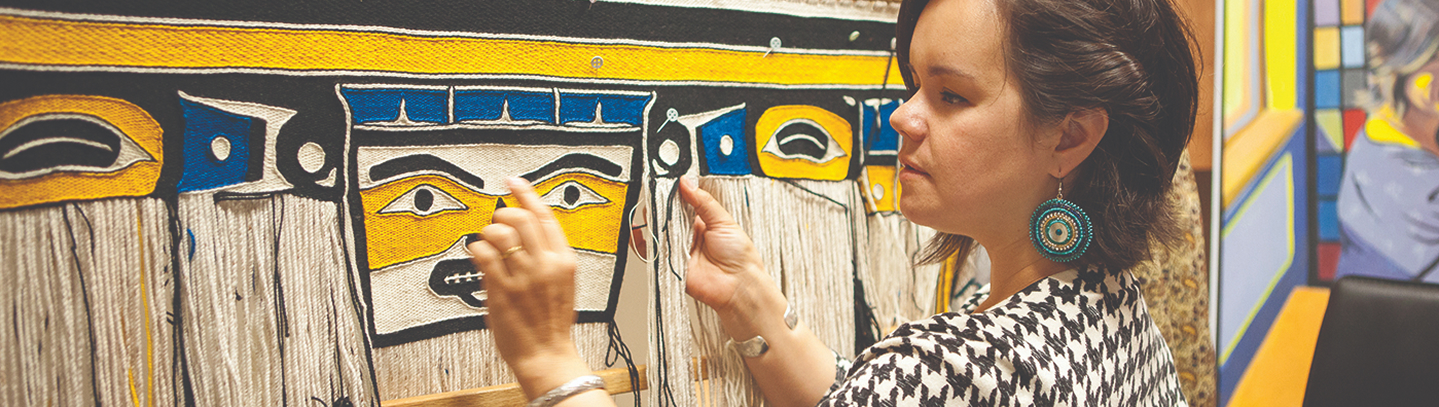 Artist weaving a colorful Northwest Coast textile on a loom