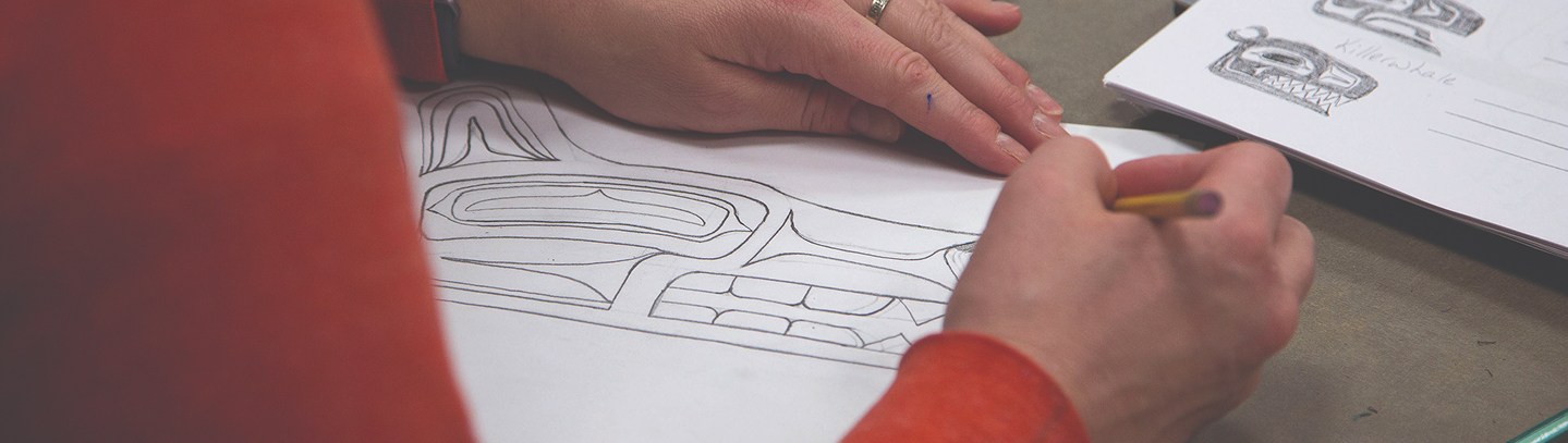 An educator drawing a Northwest Coast formline design during a workshop