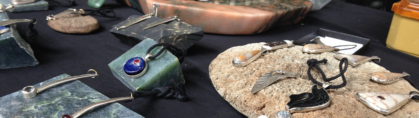 Handcrafted jewelry displayed on stone at the Native Artist Market