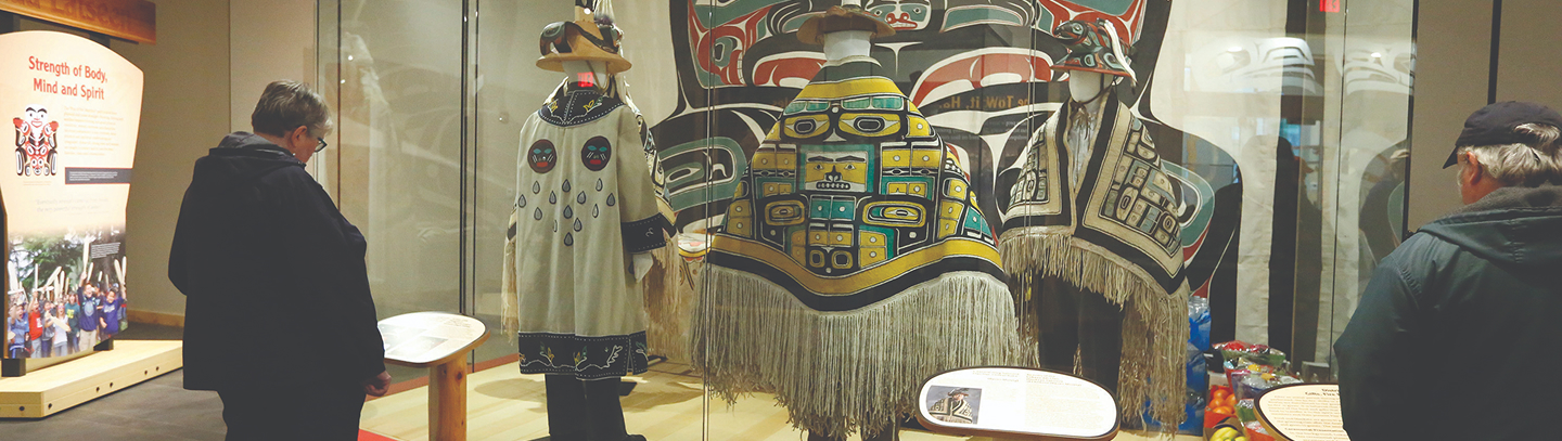 Visitors viewing clan regalia in the Nathan Jackson Gallery