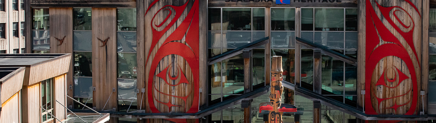 Sealaska Heritage buildings and a carved clan house post in Heritage Square