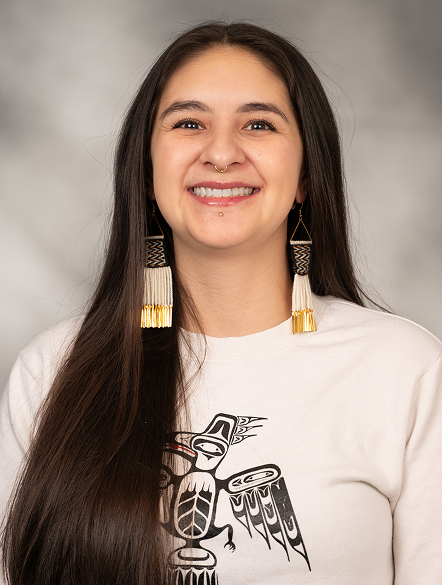 Jill Meserve wearing beaded earrings and a Raven design shirt