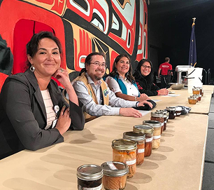 Food contest judges sit behind a row of numbered entries