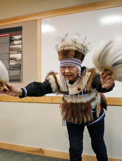 A cultural presenter wearing regalia during a lecture
