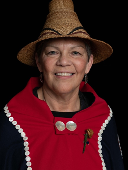Linda Schrack wearing a cedar hat and red regalia