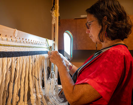 Gunashaa Lisa Fisher weaving at a loom