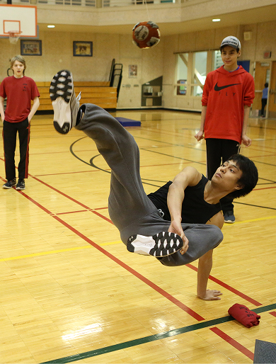Student demonstrating a traditional athletic game in a school gymnasium