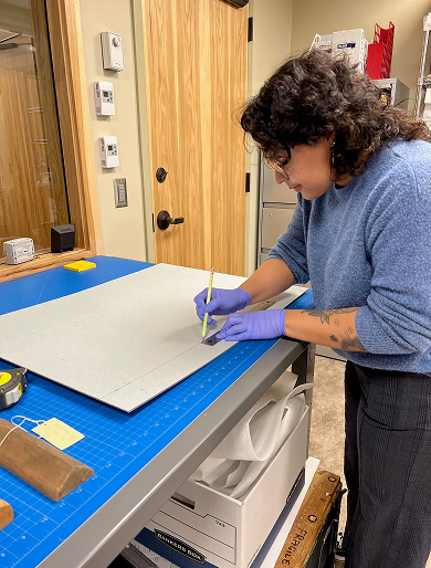 Museum studies student preparing archival material at a work table