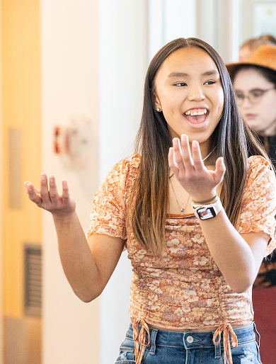 A young performer speaking and gesturing during a program