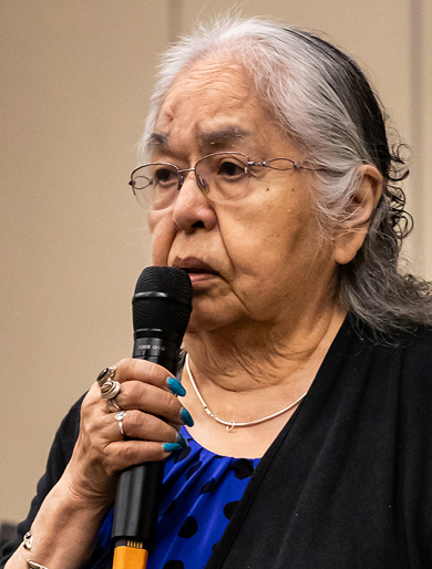 An Elder speaking into a microphone