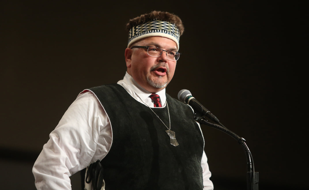 X̱úits Kéeng̱g̱ulaa Robert Edwardson speaking at a microphone