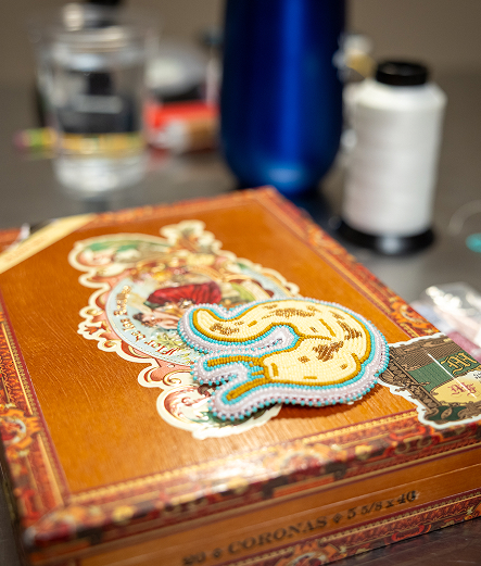 A beaded Northwest Coast artwork displayed on a wooden box