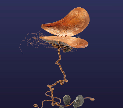 A suspended sculptural work made from carved wood, cord, and stones