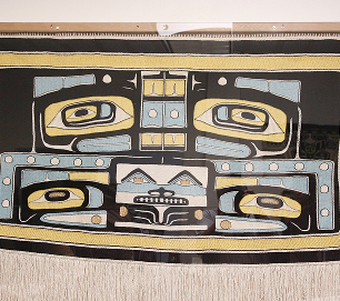 A black, cream, blue, and gold Northwest Coast woven textile
