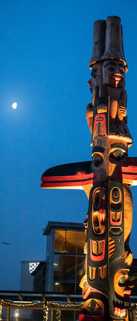 Illuminated carved Kootéeyaa against the evening sky