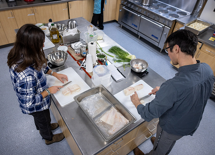 Students preparing fish in the Indigenous Science Building teaching kitchen