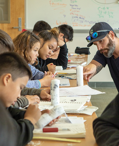 High school students learning with an instructor in a classroom