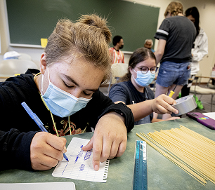 Students writing and measuring materials during a Career Pathways classroom activity