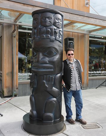Tsimshian artist David R. Boxley beside his bronze Raven house post