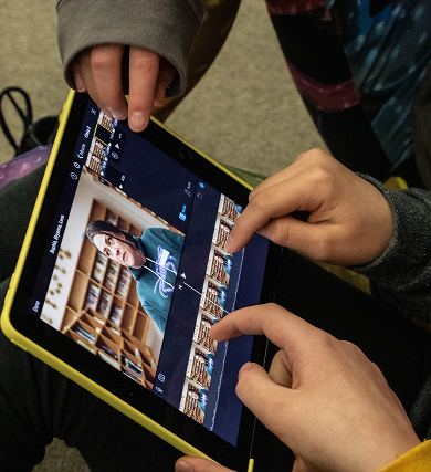 Students editing a digital story together on a tablet