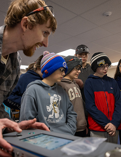 Students learning with fabrication equipment in the makerspace
