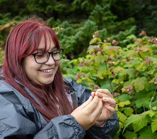 A student examining a berry during an outdoor field activity