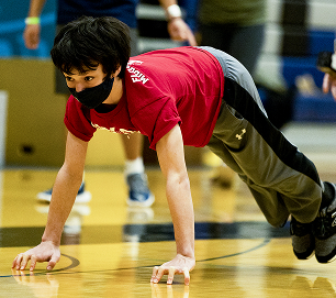 A student athlete competing in an endurance event on a gymnasium floor
