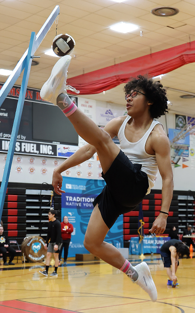 A student demonstrating a traditional athletic game in a school gymnasium