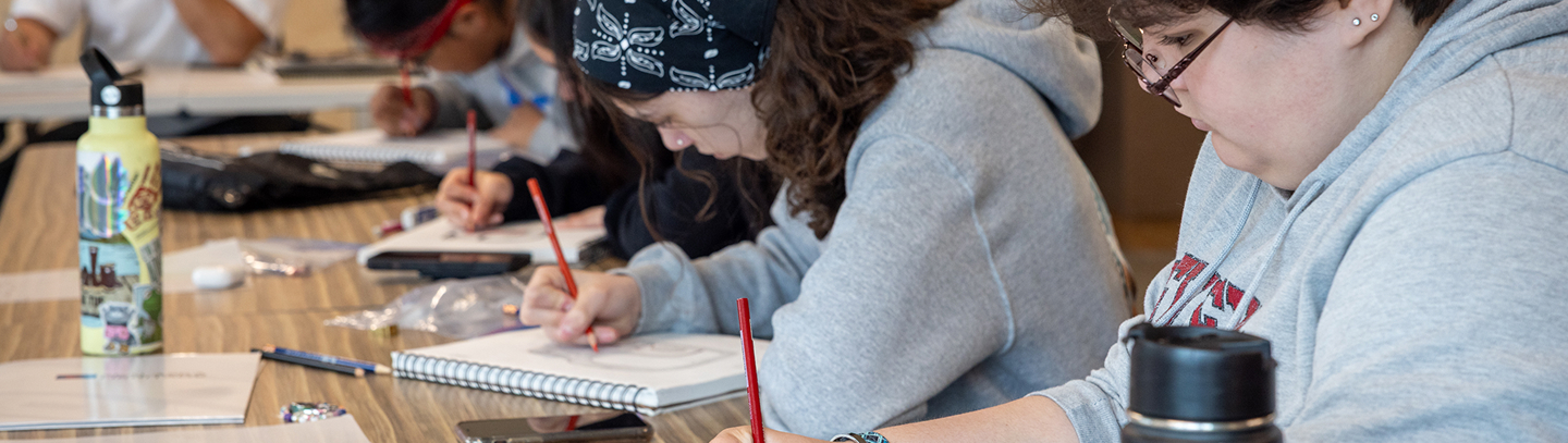 Students drawing Northwest Coast art together in a classroom