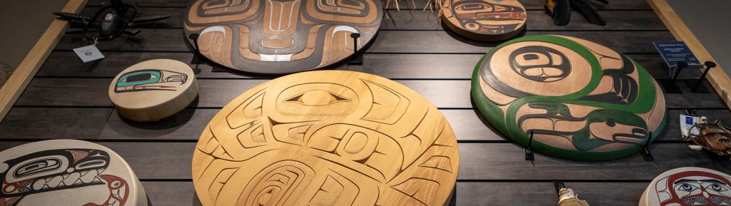 Circular carved and painted Northwest Coast artworks displayed inside the Sealaska Heritage Store