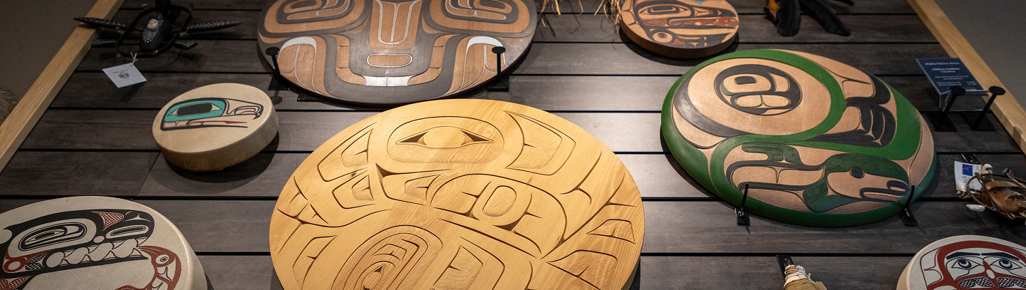 Circular carved and painted Northwest Coast artworks displayed inside the Sealaska Heritage Store