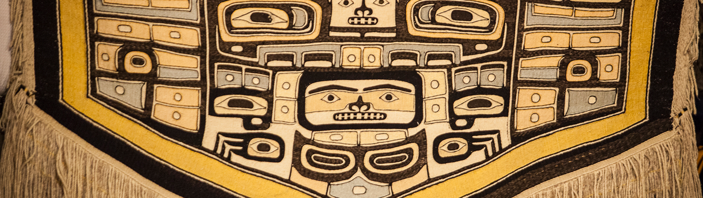 Detail of a gold, black, and cream Northwest Coast textile design with fringe