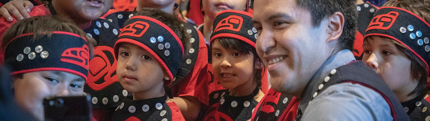 TCLL students and an educator gathered in traditional regalia