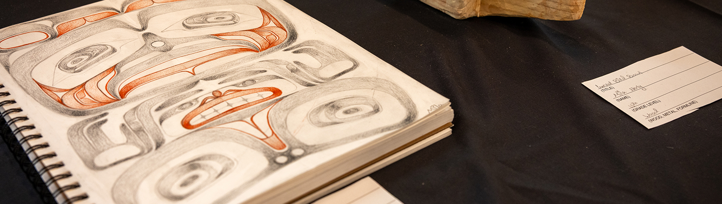 A student formline design displayed in an open sketchbook