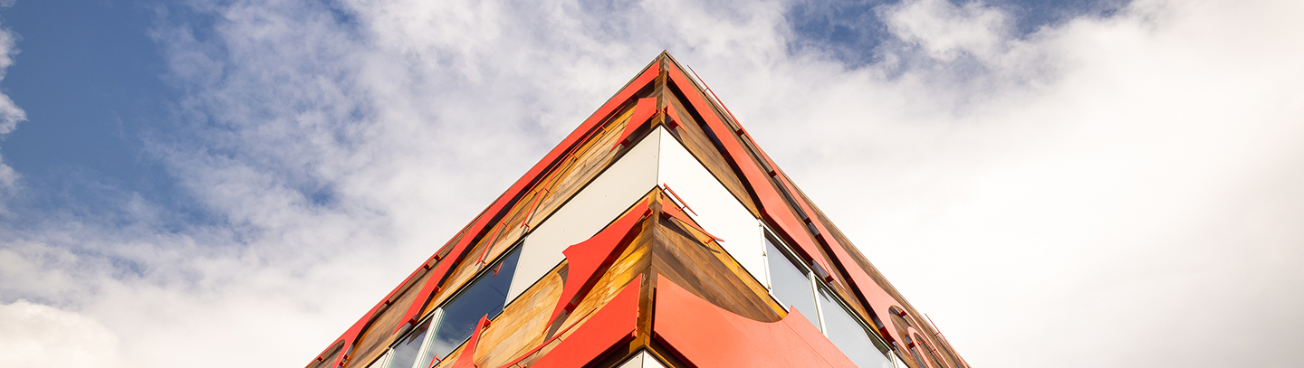 Upward view of the red formline exterior of the Indigenous Science Building