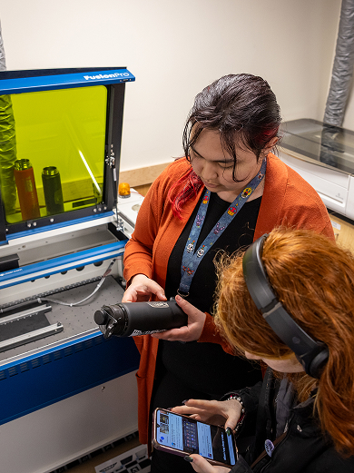 Interns documenting a project with digital tools in a fabrication lab