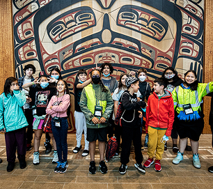 Students gathered in front of a Northwest Coast art screen during a museum visit