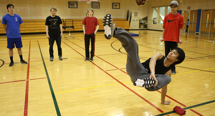 A student athlete competing in a traditional game in a gymnasium